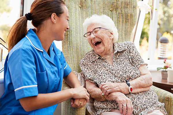 nurse and senior woman laughing